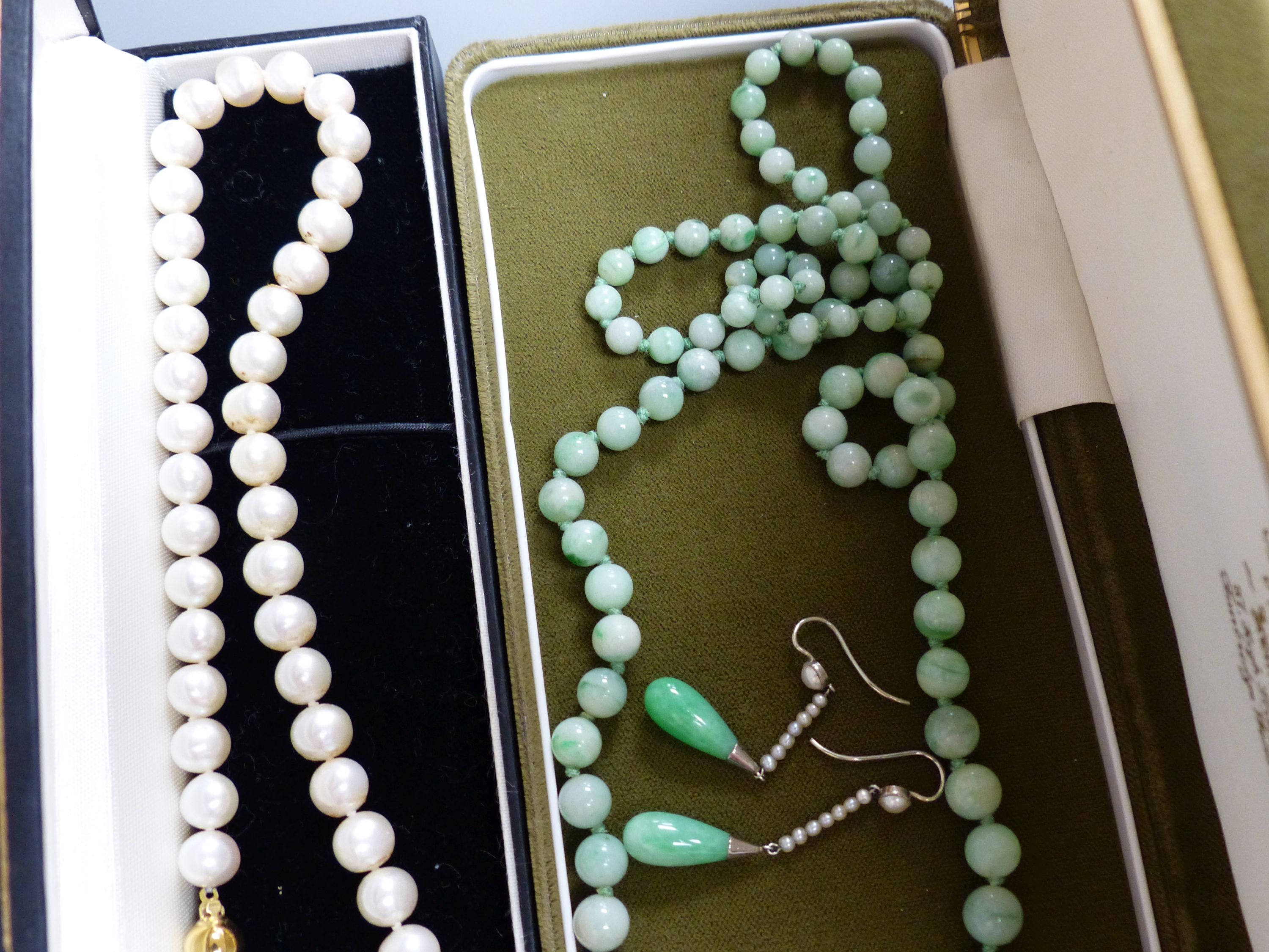 A single row uniform cultured pearl necklace with 9ct gold ball clasp, a graduated jade bead necklace and a pair of jade and seed pearl drop earrings, 37mm